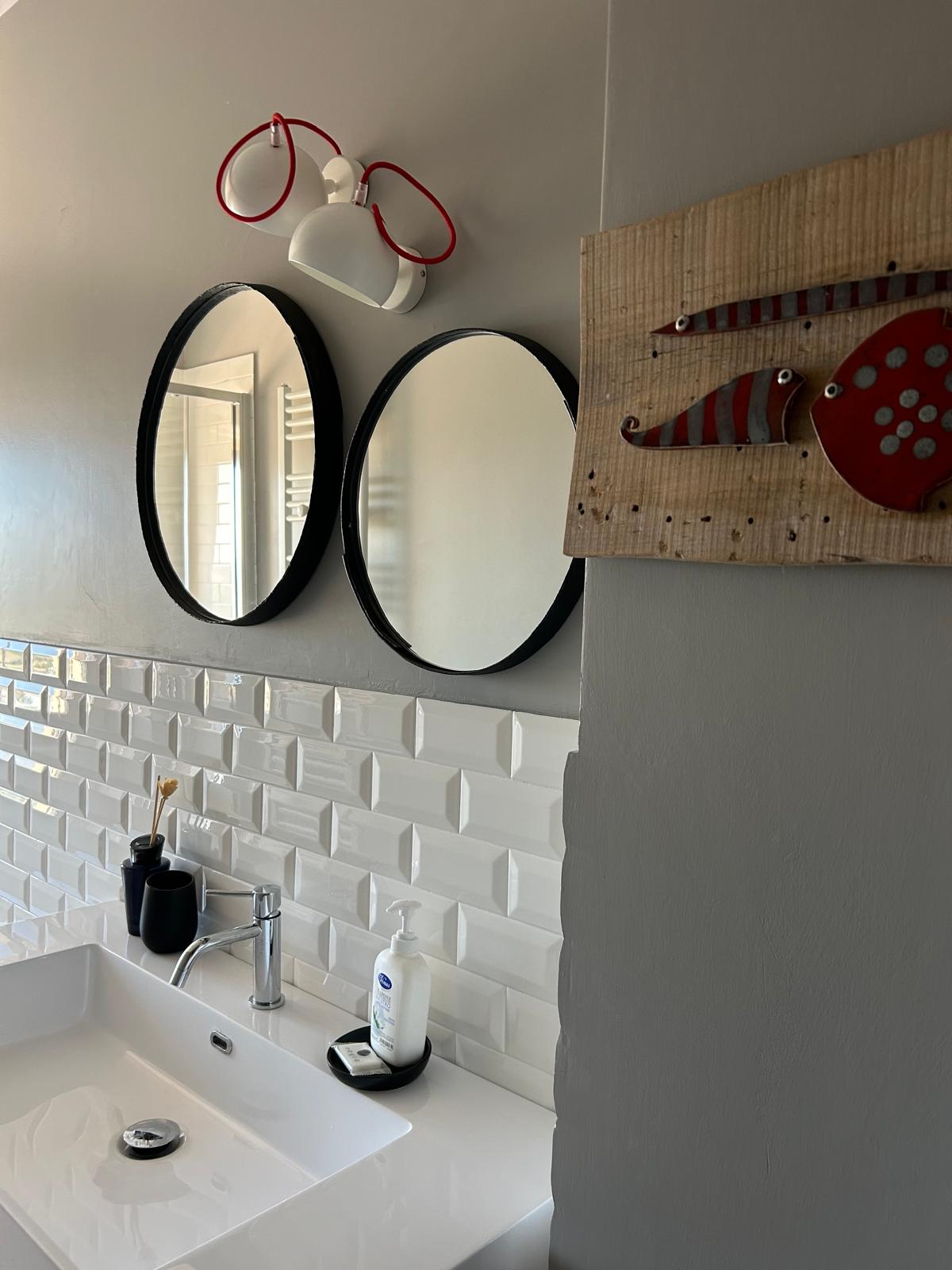 Dettaglio del bagno con specchi tondi