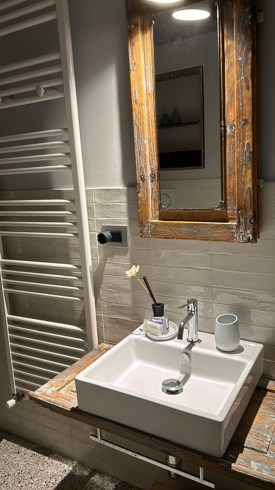 Dettaglio del bagno con lavabo su legno di recupero